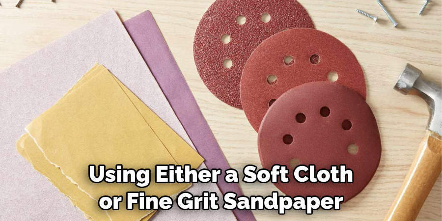 Using Either a Soft Cloth or Fine Grit Sandpaper